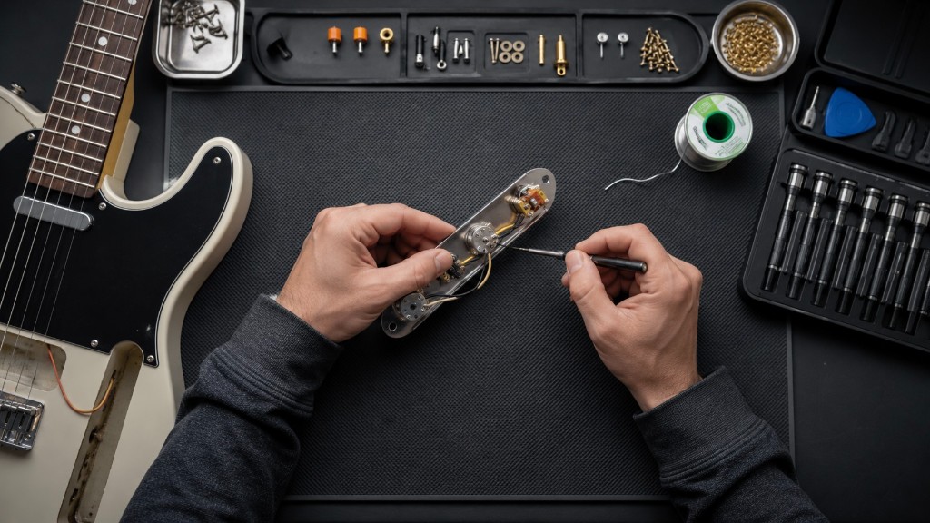 Técnico reparando la electrónica de una guitarra eléctrica en taller
